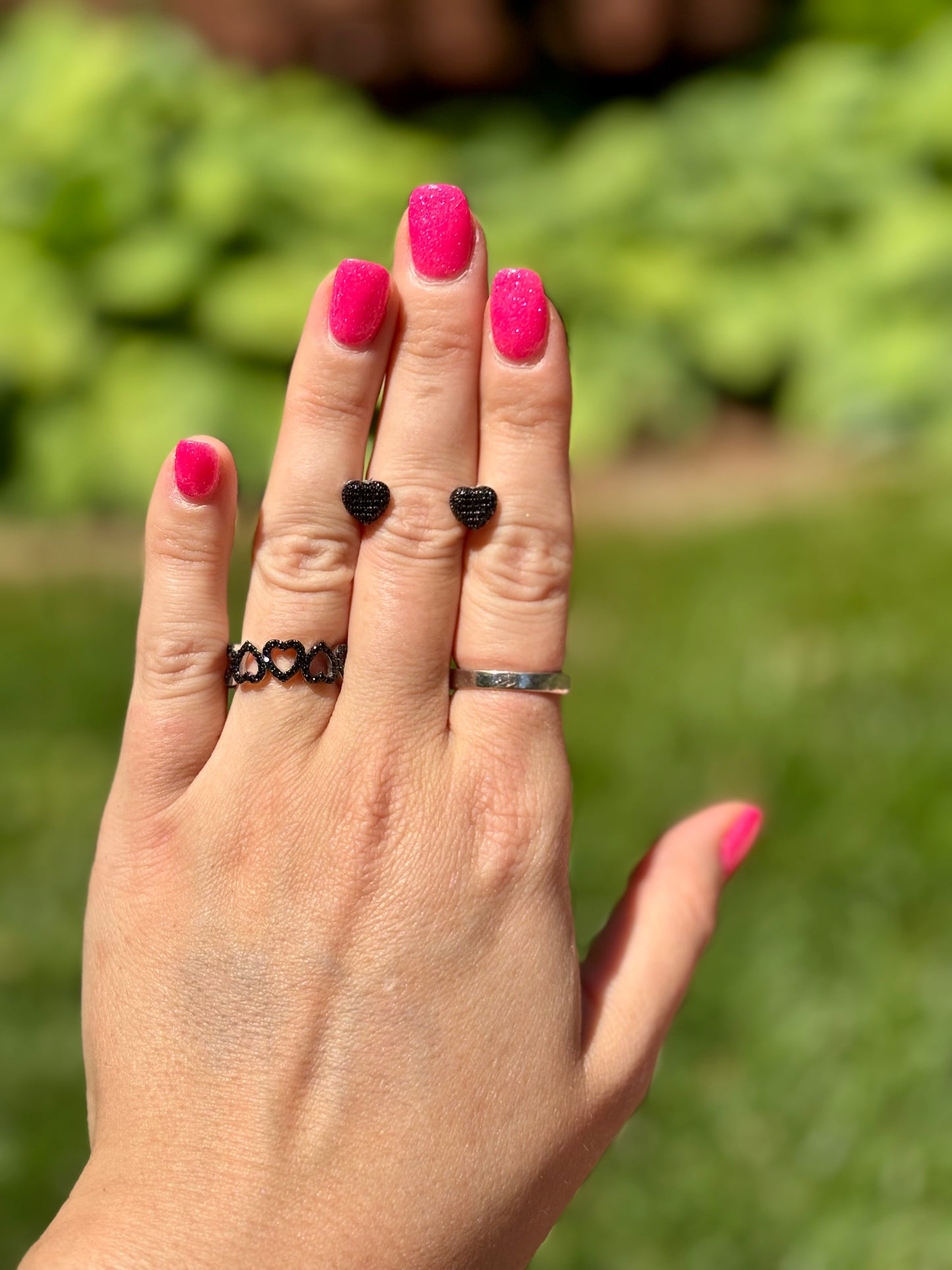 Sterling silver black spinel heart eternity ring, modeled on hand